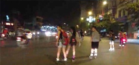 Dắt tay nhau dàn hàng ngang trượt patin qua đường (ảnh cắt từ clip)