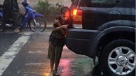 Dân mạng nghẹn lòng trước bức ảnh em bé nép mình bên ô tô để trú mưa
