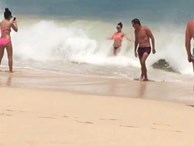 Hớn hở thả dáng chụp hình bên bờ biển, cô gái bị sóng đánh ngã sấp mặt xuống cát