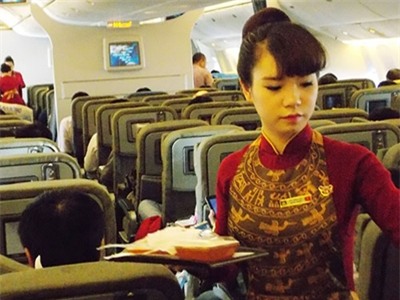Tiếp viên của hãng VNA phục vụ hành khách trên một chuyến bay.