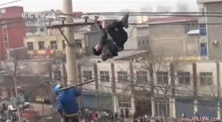 Gã say xỉn vắt vẻo trên dây điện. Ảnh: CCTV