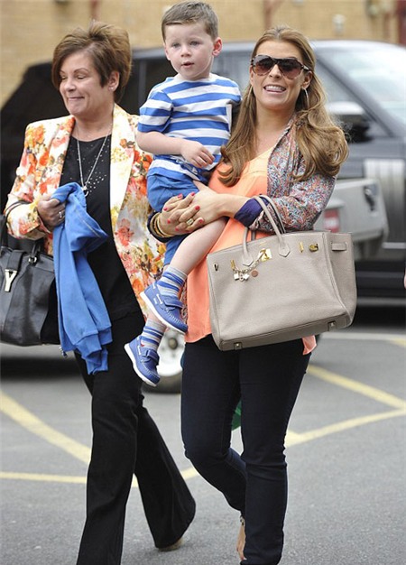 Coleen vẫn nở nụ cười tinh nghịch với các tay săn ảnh dù đang lệch sườn vì bế con.