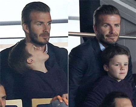 Becks vừa bế bé Cruz vừa chăm chú theo dõi trận đấu căng thẳng của các đồng đội.
