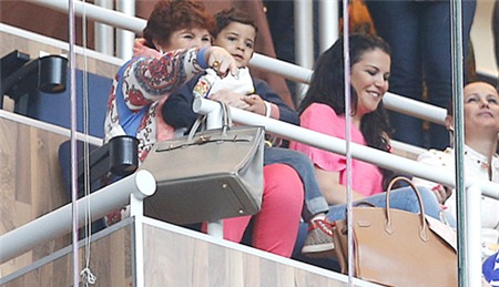 Cậu bé quàng chiếc khăn truyền thống của Real, chăm chú xem bố thi đấu.