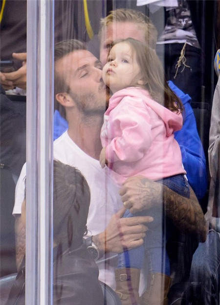 Vừa bế con vừa xem hockey, Becks không quên thể hiện tình cảm với Harper.
