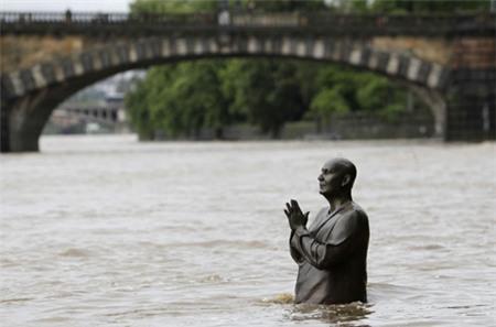 The statue of world harmony leader Sri Chinmoy is partially submerged in water from the rising Vltava river in Prague June 2, 2013. Rivers across the Czech Republic are rising fast due to heavy rain. REUTERS/David W Cerny (CZECH REPUBLIC - Tags: DISASTER ENVIRONMENT TPX IMAGES OF THE DAY) less