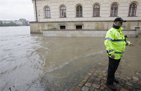 A police officer stands on the swollen Vltava river bank at the medieval Kampa in Prague June 2, 2013. Rivers across the Czech Republic are rising fast due to heavy rain. REUTERS/David W Cerny (CZECH REPUBLIC - Tags: DISASTER ENVIRONMENT) less