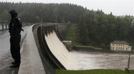 A policeman stands by the Husinec Dam in south Bohemia June 2, 2013. Czech soldiers erected metal barriers and piled up sandbags on Sunday to protect Prague's historic center from flooding after days of heavy rains swelled rivers and forced evacuations from some low-laying areas. REUTERS
