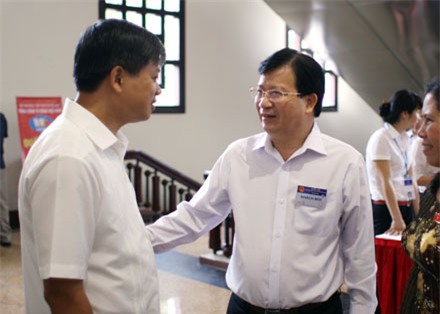 Bộ trưởng Trịnh Đình Dũng (phải) trao đổi tại hành lang Quốc hội