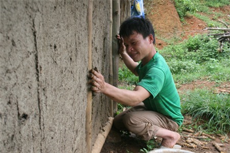 Anh Lệ dùng phân trâu trát vào những chỗ còn hở của bờ vách.