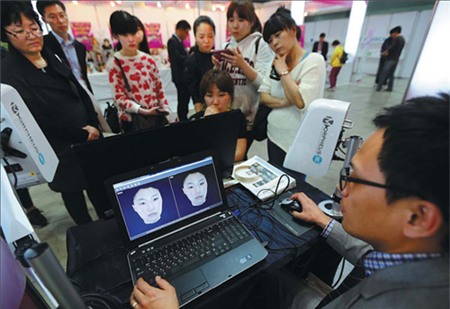 Khách tham quan tại một gian trưng bày những bức ảnh 3D về khuôn mặt trước và sau khi thẩm mỹ, tại một triển lãm quốc tế ở Seoul hồi tháng 4. Ảnh: China daily