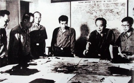 Quân ủy Trung ương đang theo dõi diễn biến Chiến dịch Hồ Chí Minh năm 1975. Trong ảnh, từ trái sang phải: Đại tá Lê Hữu Đức (Cục trưởng Cục tác chiến, Thượng tướng Hoàng Văn Thái (Phó tổng tham mưu), thiếu tướng Vũ Xuân Chiêm (Phó chủ nhiệm Tổng cục Hậu cần), Thượng tướng Song Hào (Chủ nhiệm Tổng cục Chính trị), Đại tướng Võ Nguyên Giáp (Tổng tư lệnh, Bộ trưởng Quốc phòng, Bí thư Quận ủy Trung ương), Trung tướng Lê Quang Đạo (Phó Chủ nhiệm Tổng cục Chính trị). Trong ảnh, từ trái sang phải: Đại tá Lê Hữu Đức (Cục trưởng Cục tác chiến, Thượng tướng Hoàng Văn Thái (Phó tổng tham mưu), thiếu tướng Vũ Xuân Chiêm (Phó chủ nhiệm Tổng cục Hậu cần), Thượng tướng Song Hào (Chủ nhiệm Tổng cục Chính trị), Đại tướng Võ Nguyên Giáp (Tổng tư lệnh, Bộ trưởng Quốc phòng, Bí thư Quận ủy Trung ương), Trung tướng Lê Quang Đạo (Phó Chủ nhiệm Tổng cục Chính trị).