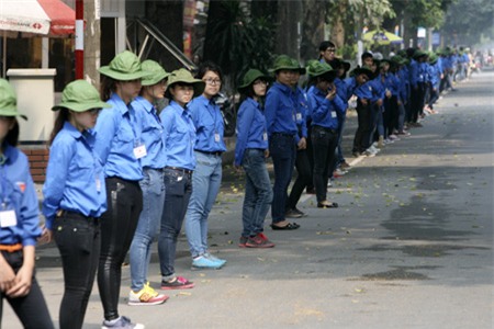 Các sinh viên tình nguyện đứng thành hàng bảo đảm giao thông trên nhiều tuyến phố.