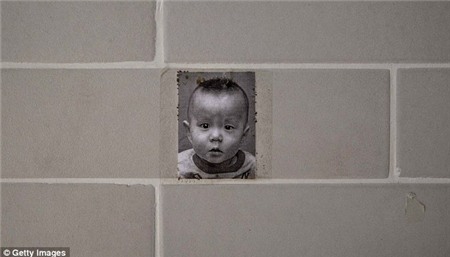 Một bức ảnh của một cậu bé mồ côi Trung Quốc treo trên tường tại một trung tâm chăm sóc nuôi dưỡng ở Bắc Kinh