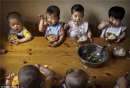 Thời gian ăn tối: trẻ em Trung Quốc trẻ mồ côi ăn một bữa ăn tại trung tâm. Ngay cả khi Trung Quốc bắt đầu để thư giãn các chính sách một con, cho phép hàng triệu gia đình có một đứa con thứ hai, nó vẫn còn gây bất lợi cho những người coi thường các quy tắc