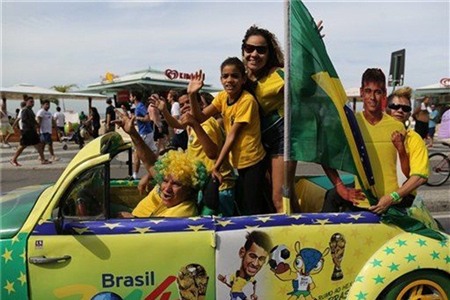 Người hâm mộ bóng đá Brazil trong màu cờ tổ quốc trên bãi biển Rio de Janeiro ngày 23/6/2014. 