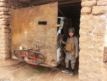 Pose: Another picture shows him smiling sweetly while wearing an ammunition vest as he stands next to a van that has been converted into an armoured vehicle with a large plank of wood and bull bars