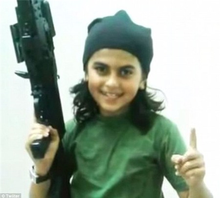 Smiling: Describing the child as ISIS youngest foreign jihadist, chilling photographs taken before his alleged death show him grinning at the camera, wearing military fatigues and brandishing a huge assault rifle