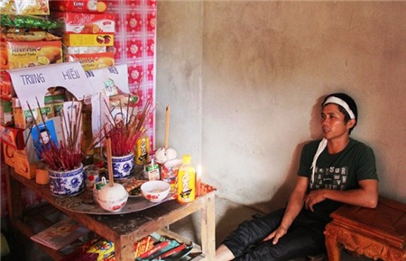 Anh Cẩm thẫn thờ ngồi bệt bên bàn thờ hai con của mình.