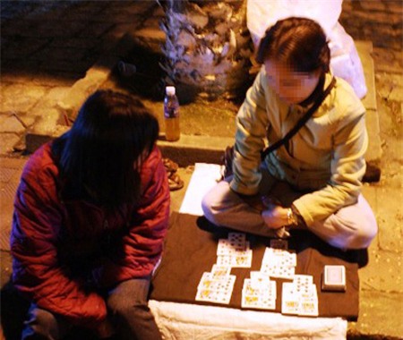 Bạn trẻ xem bói bài tây trên vỉa hè để đoán vận mệnh tương lai của mình.