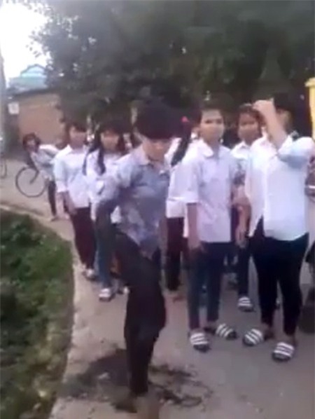 Bùn đất lấm lem bộ đồng phụ học sinh sau khi nữ sinh này được bạn kéo lên