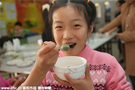 Một cô bé thưởng thức món bánh trôi tại Qinhuangdao, tỉnh Hà Bắc. 