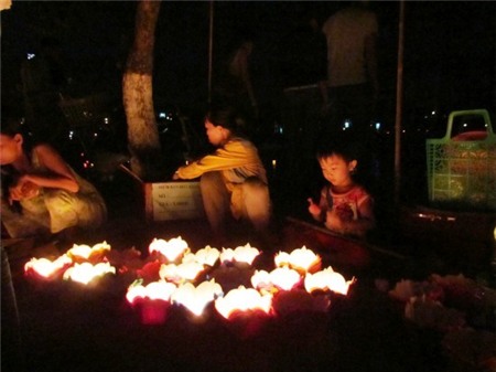 Một bé trai tỏ ra thích thú khi ngắm đèn lồng tại Hội An. Vào ngày 14 hoặc chính rằm, người dân đã tấp nập đến chùa lễ Phật, cầu bình an, khoẻ mạnh, hạnh phúc… cho cả năm. Ngoài tới chùa, người Việt cũng rất coi trọng lễ cúng tại nhà. 