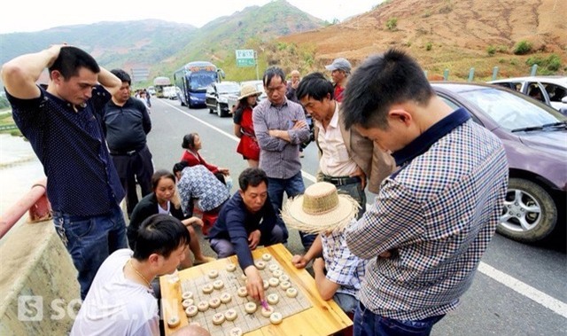 Không thể ngồi yên trên xe chờ đợi cho đến khi đường hết tắc, những người đàn ông này bỏ cờ tướng ra đánh ngay trên đường cao tốc