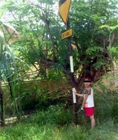 Bà xích cháu 4 tuổi vào biển báo ven đường vì không làm bài tập về nhà