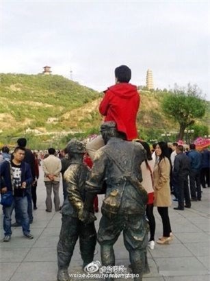 TQ: Nguoi phu nu ngoi len dau tuong linh de chup anh