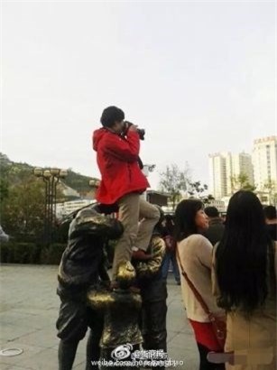 TQ: Nguoi phu nu ngoi len dau tuong linh de chup anh