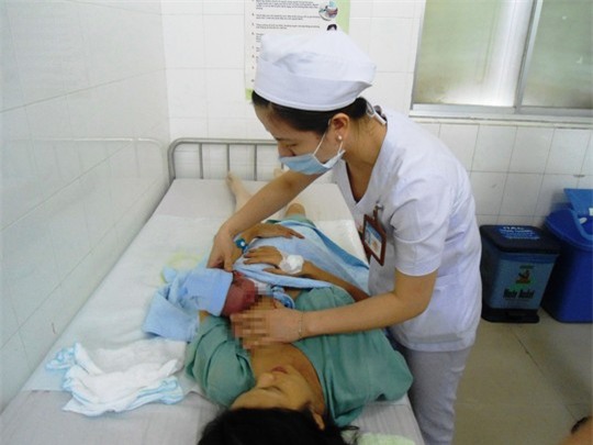 Sản phụ nên có chế độ vận động, dinh dưỡng, vệ sinh cơ thể, chăm sóc bé... theo hướng dẫn của nhân viên y tế. Trong ảnh: Nữ hộ sinh của Bệnh viện Từ Dũ hướng dẫn sản phụ cách chăm sóc bé