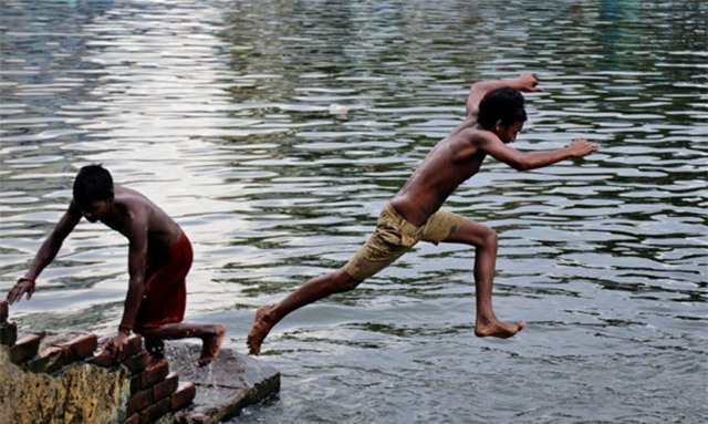 Trẻ em Ấn Độ tắm sông ở Kolkata, bang Tây Bengal. Hơn 35 người đã tử vong tại bang vì trời nóng. Giới chức Ấn Độ cho biết, những bang có người thiệt mạng và bị suy giảm sức khỏe do trời nóng chủ yếu là các địa phương phía nam. Số ca tử vong tăng nhanh trong 4 ngày qua. Ảnh: AP