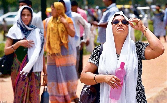 Phụ nữ che chắn cơ thể khi ra đường dưới trời nắng gắt ở thủ đô New Delhi. 