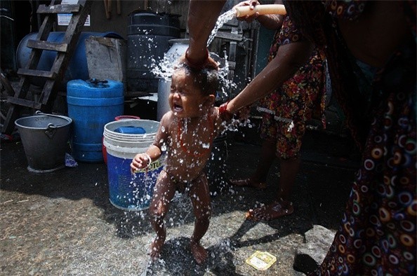 Một bà mẹ tắm cho con tại Mumbai ngày 29/5. Theo trang Hindustan Times, số người thiệt mạng vì nắng nóng trên cả nước đã vượt mốc 2.000 người vào ngày 30/5. 