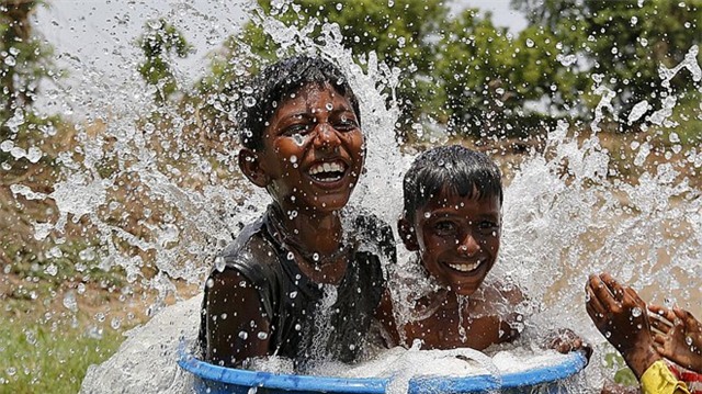  Những bé trai tắm trong thùng nước để giải nhiệt ở thành phố Ahmedabad, bang Gujarat. Nhiều địa phương ở Ấn Độ luôn có nhiệt độ trên 40 độ C. Thành phố Palamau ở bang Jharkhand, miền đông Ấn Độ, đang là địa phương có nhiệt độ cao nhất: 47 độ C.