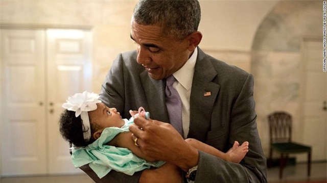 Nét mặt biểu cảm của Obama khi bế con gái của cựu nhân viên Nhà Trắng Darienne Page Rakestraw  