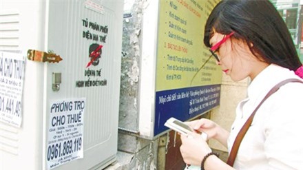 Sinh viên Nguyễn Thị Mỹ Hoa đang liên hệ với thông tin cho thuê nhà trọ được dán trên tủ phân phối điện hạ thế. Ảnh: P.V.