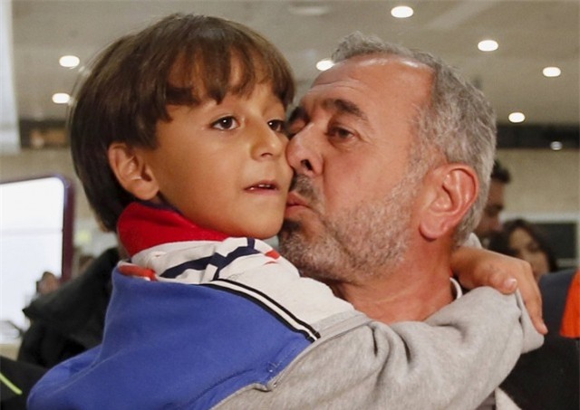 Ông Osama Abdul Mohsen bế con trai 7 tuổi trên tay