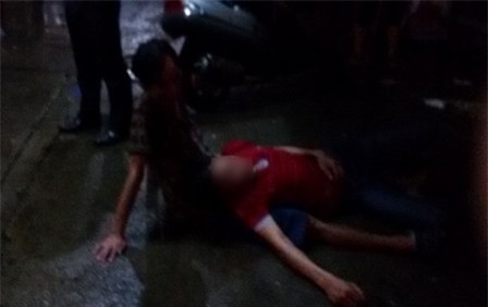 Hai thanh niên vật vã trong cơn say nằm giữa đường khi trời đang mưa