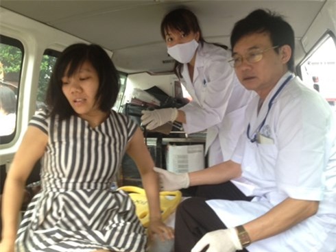 Nạn nhân Huyền trên người dính nhiều máu vừa được đưa ra khỏi đống đổ nát. Chị Huyền cho biết, trong đống đổ nát còn nhiều người mắc kẹt, vì phía sau ngôi nhà này là một chợ cóc. Ảnh: VOV