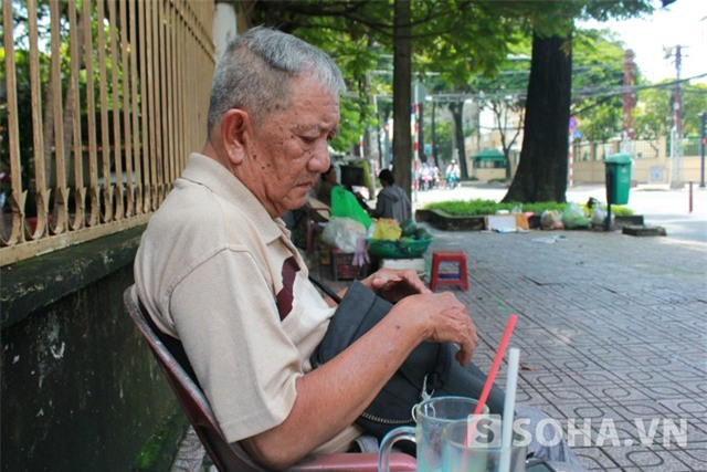 Nghệ sĩ Mạc Can ngồi ở quán cafe ven đường, nơi ông vẫn thường lui tới.