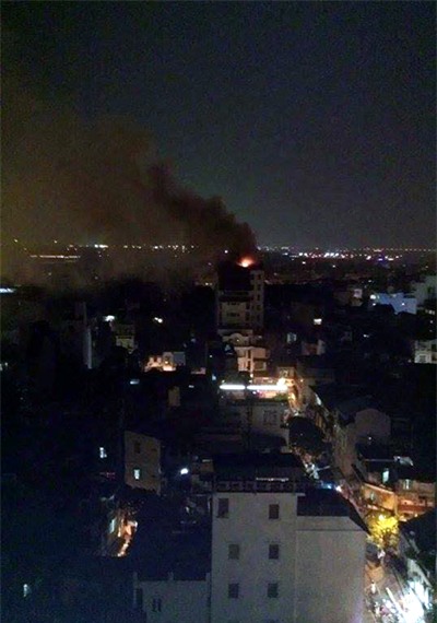 Nhìn từ xa có thể thấy cột khói đen bốc cao từ nóc khách sạn. (Ảnh: Tiến Nguyên)