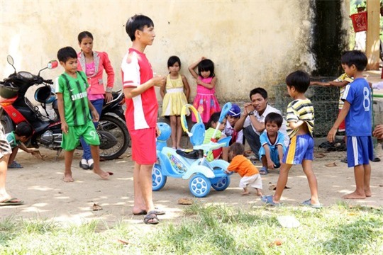 Đinh Văn KRể (đẩy xe) bé nhỏ so với các bạn cùng trang lứa khác