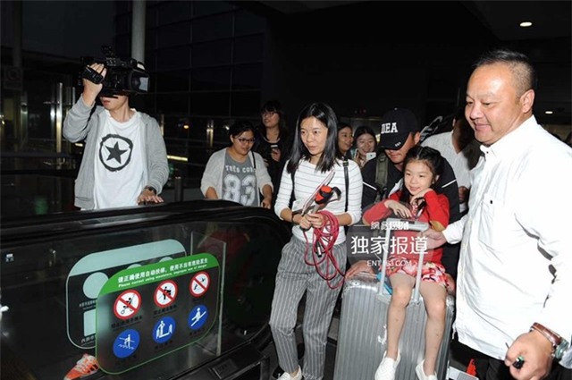 Tài tử Ngô Kinh cùng con nuôi trong vòng vây phóng viên. Anh là phù rể của Huỳnh Hiểu Minh.