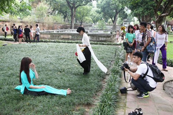 Nữ sinh ngồi lên cỏ chụp kỷ yếu mặc biển cấm ở Văn Miếu