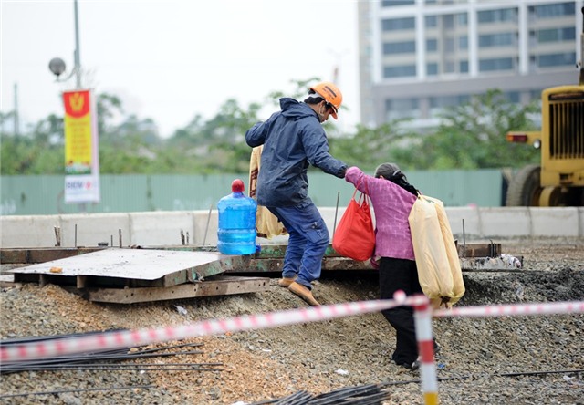 Còn người đi bộ thì lo nơm nớp mỗi khi qua đường. Một bà cụ bán bánh mì đã phải nhờ một anh công nhân để trèo qua đống đất đá do lối đi bộ sang đường đã bị công trường chặn mất.