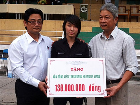 Chủ tịch Liên đoàn Taekwondo Việt Nam - Ông Trương Ngọc Để và ông Lê Văn Nghĩa - Nguyên Chủ tịch Hội Taekwondo TP HCM trao số tiền ủng hộ được cho VĐV Hoàng Hà Giang
