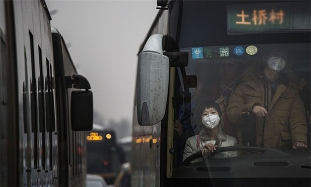 Người dân đeo khẩu trang, chen chúc trên một xe buýt. Chính quyền cảnh báo, tình trạng khói nghiêm trọng sẽ kéo dài hơn 3 ngày. Họ thông báo lịch hoạt động cho các xe hơi mang biển số chẵn, lẻ. Quyết định này được thực thi từ 7h ngày 8/12 và kéo dài tới 12h ngày 10/12 khi tình trạng sương mù chấm dứt. Ảnh: Getty