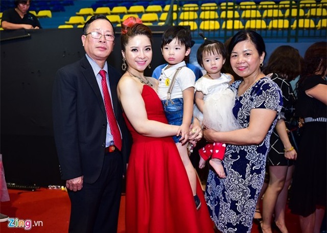 Huyền Thanh (váy đỏ) chụp ảnh cùng bố mẹ và hai con nhỏ. Bà mẹ đơn thân hạnh phúc khi giảm thành công 23 kg nhờ cuộc thi Bước nhảy ngàn cân. Ảnh: Bá Ngọc. 
